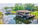 Covered boat dock on a serene lake, featuring a tile roof and ample space for watercraft at 10352 Burris Ct, Orlando, FL 32836