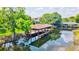 Picturesque view of a covered boat dock on the water, surrounded by lush greenery and reflective water at 10352 Burris Ct, Orlando, FL 32836