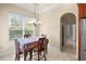 Bright dining room with large window, chandelier, and access to hallway at 10352 Burris Ct, Orlando, FL 32836