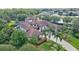 Aerial view of the home with beautiful landscaping, a driveway, and a grand entrance at 10352 Burris Ct, Orlando, FL 32836