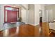 Foyer with hardwood floors transitions into slate flooring with red double doors and decorative columns at 10352 Burris Ct, Orlando, FL 32836