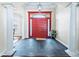 Grand foyer with a striking red double door, soaring columns, and elegant tile flooring at 10352 Burris Ct, Orlando, FL 32836