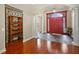 Elegant foyer with hardwood floors, columns, a red door, and a decorative wine storage unit at 10352 Burris Ct, Orlando, FL 32836