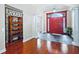 Elegant foyer featuring a red door, tile flooring, an archway, and ornate iron decor at 10352 Burris Ct, Orlando, FL 32836
