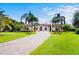 Elegant estate featuring a paver driveway, meticulously manicured landscaping, and grand facade at 10352 Burris Ct, Orlando, FL 32836