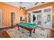 A game room with a pool table, hardwood floors, and outdoor views at 10352 Burris Ct, Orlando, FL 32836