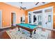 Spacious game room with pool table, hardwood floors, and french doors leading to an outdoor living space at 10352 Burris Ct, Orlando, FL 32836