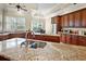 Kitchen featuring granite countertops, a stainless steel sink, and wood cabinets at 10352 Burris Ct, Orlando, FL 32836