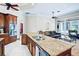 Bright kitchen with a granite island, stainless steel appliances, and open floor plan flowing into the living room at 10352 Burris Ct, Orlando, FL 32836