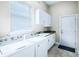 Functional laundry room with a sink, cabinets, washer, dryer, and a window providing natural light at 10352 Burris Ct, Orlando, FL 32836