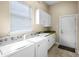 Bright laundry room with white cabinets, countertops, and modern washer and dryer at 10352 Burris Ct, Orlando, FL 32836