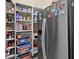 Well-organized pantry with white shelves and a modern, stainless steel refrigerator at 10352 Burris Ct, Orlando, FL 32836