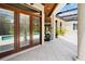 Covered patio boasts tile flooring, columns, and french doors to a covered lanai and pool area at 10352 Burris Ct, Orlando, FL 32836