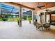 Beautiful covered patio features a ceiling fan, dining table, and a view of the pool and well manicured lawn at 10352 Burris Ct, Orlando, FL 32836