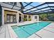 A sparkling pool is the focal point of this beautiful screened-in outdoor entertainment area at 10352 Burris Ct, Orlando, FL 32836