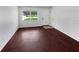 Spacious and modern living room with hardwood floors, a large window, and white walls at 14837 Sussex Dr, Orlando, FL 32826