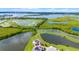 Stunning aerial view of the expansive property featuring multiple ponds and lush greenery, backing onto a large lake at 15208 Lake Claire Overlook Dr, Winter Garden, FL 34787