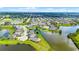 Modern home with a lakefront view surrounded by a lush green community from an aerial view at 15208 Lake Claire Overlook Dr, Winter Garden, FL 34787
