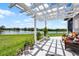 Backyard trellis patio with outdoor seating overlooking a peaceful pond at 15208 Lake Claire Overlook Dr, Winter Garden, FL 34787