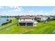 Expansive backyard with a screened porch, pergola, and waterfront view, perfect for outdoor relaxation and entertaining at 15208 Lake Claire Overlook Dr, Winter Garden, FL 34787