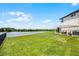 Large backyard with trellis and patio, leading to a tranquil pond at 15208 Lake Claire Overlook Dr, Winter Garden, FL 34787