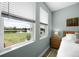 Bedroom showcasing a large window with views of the lush greenery and serene lake at 15208 Lake Claire Overlook Dr, Winter Garden, FL 34787