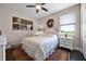 Cozy bedroom with a ceiling fan, decorative artwork, and a large window offering natural light at 15208 Lake Claire Overlook Dr, Winter Garden, FL 34787