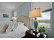 Comfortable bedroom featuring a tufted headboard, a lake view, and stylish decor at 15208 Lake Claire Overlook Dr, Winter Garden, FL 34787