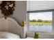 Bedroom featuring a window with a view of the lush backyard and serene lake at 15208 Lake Claire Overlook Dr, Winter Garden, FL 34787
