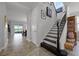 Well-lit entryway with tiled floors and staircase with black iron spindles at 15208 Lake Claire Overlook Dr, Winter Garden, FL 34787