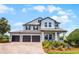 Charming two-story home boasts a three-car garage, covered porch, and manicured landscaping at 15208 Lake Claire Overlook Dr, Winter Garden, FL 34787