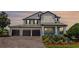 Charming home with a three-car garage, brick driveway, and inviting front porch with mature landscaping at 15208 Lake Claire Overlook Dr, Winter Garden, FL 34787