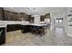 Stunning kitchen with a large center island with seating, ample dark cabinetry, and tiled floors at 15208 Lake Claire Overlook Dr, Winter Garden, FL 34787