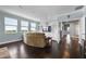 Light-filled living room with hardwood floors and a sofa, offering serene views through large windows at 15208 Lake Claire Overlook Dr, Winter Garden, FL 34787