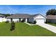 Inviting home featuring lush green lawn, concrete driveway, and attached two-car garage at 15476 Sw 34Th Court Rd, Ocala, FL 34473