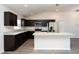 Modern kitchen featuring dark cabinets, stainless steel appliances, and a center island at 15476 Sw 34Th Court Rd, Ocala, FL 34473