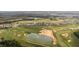 Expansive aerial view showcasing a golf course community with luxury homes and scenic water features at 15947 Vetta Dr, Bella Collina, FL 34756