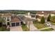 Aerial view of a stunning home with manicured lawn, paver driveway, and attached two-car garage at 15947 Vetta Dr, Bella Collina, FL 34756