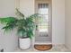 Charming front entry with decorative plant and an elegant glass-panel front door at 15947 Vetta Dr, Bella Collina, FL 34756