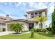 Beautiful home featuring a two-car garage, manicured lawn, and lush tropical landscaping at 15947 Vetta Dr, Bella Collina, FL 34756