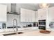 Modern kitchen featuring white cabinetry, stainless steel appliances, and a stylish backsplash at 15947 Vetta Dr, Bella Collina, FL 34756