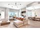 Bright, open living room with a sectional sofa, modern lighting, bar area, and sliding doors to a patio at 15947 Vetta Dr, Bella Collina, FL 34756