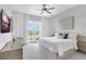 Bright main bedroom with balcony access, plush bedding, and a ceiling fan at 15947 Vetta Dr, Bella Collina, FL 34756