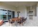 Outdoor patio with large dining table, grill, and sliding glass doors is perfect for al fresco dining and entertaining at 15947 Vetta Dr, Bella Collina, FL 34756