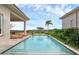 Relax by the clear pool surrounded by an umbrella, lush greenery, and inviting outdoor lounge spaces at 15947 Vetta Dr, Bella Collina, FL 34756