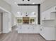 Open kitchen with modern white cabinets, quartz countertops, and an adjacent living area at 1617 Hallcrest Dr, Deltona, FL 32725