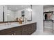 Modern bathroom with dual sinks, quartz countertops, stylish lighting, and a spacious walk-in closet at 1618 Bellagio Loop, Tavares, FL 32778