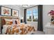 Bright bedroom featuring a large window, floral bedding, and modern decor at 1618 Bellagio Loop, Tavares, FL 32778