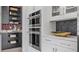 Close up of modern built-in stainless double oven, kitchen cabinets, and pantry for ample storage space at 1618 Bellagio Loop, Tavares, FL 32778