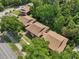 Aerial view of the condo complex surrounded by lush trees, street access, and parking spaces at 168 Perimeter Ct # 5C, Deltona, FL 32725